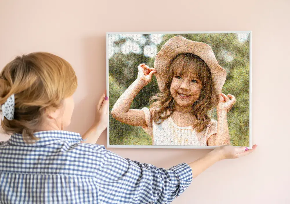 White-framed photo mosaic of a girl in a hat on a pink wall, a custom photo gift for the family